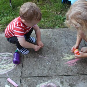 Children drawing with sidewalk chalk
