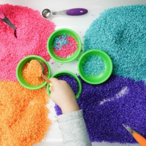 Around the world theme preschool activity rice dyed in four colors pink, orange, teal and purple