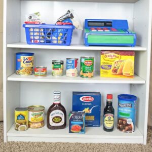 Around the world theme preschool activity with international foods on a white shelf