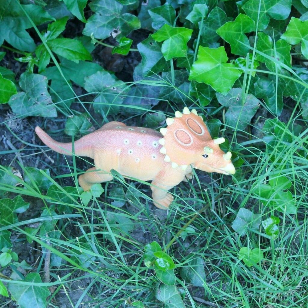 Dinosaur preschool activity playing with dinosaurs outside in a grass 'jungle'