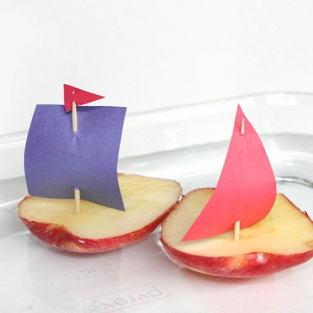 2 apple boats in a tray of water science for preschool