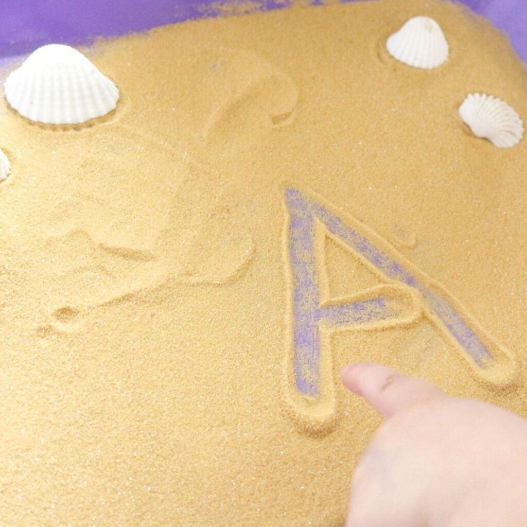 Writing in sand ocean activity for preschool.
